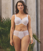 Model wearing Fantasie Fusion Bra and Brief Set in White set against neutral background with plants