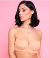 Woman wearing a boob tape against a pink background