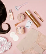 Collection of beauty and personal care products including boob tape on a pink background