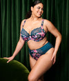 Model wearing Elomi Lucie Plunge Bra and High Leg Brief set in Teal Floral set against green curtain backdrop